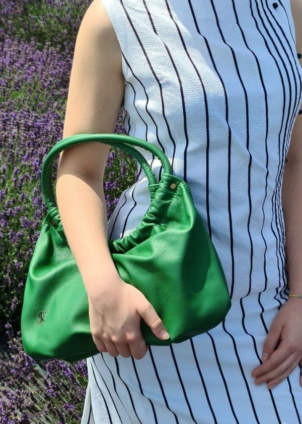 Zelená kožená kabelka do ruky od SussesBag v outfite s bielo-čiernymi šatami